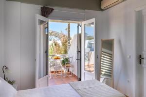 a bedroom with a bed and a balcony with a table at Mare in Galissas