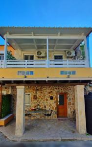 a large house with a balcony and a table at MyrillasHome in Lefkímmi