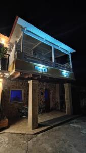 a building with a balcony with blue lights on it at MyrillasHome in Lefkímmi