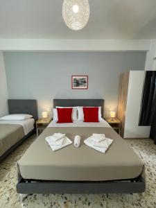a bedroom with a large bed with red pillows at Trastevere Station Sweet Rest in Rome