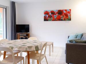 ein Wohnzimmer mit einem Tisch und Stühlen sowie einem TV in der Unterkunft Appartement Bormes-les-Mimosas, 2 pièces, 4 personnes - FR-1-610-99 in Bormes-les-Mimosas