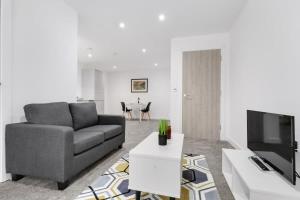 a living room with a couch and a tv at Spacious Studio Apartment in Central Newbury in Newbury