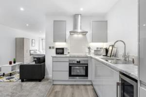een witte keuken met een wastafel en een fornuis bij Spacious Studio Apartment in Central Newbury in Newbury