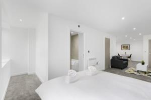 a white room with a couch and a living room at Spacious Studio Apartment in Central Newbury in Newbury