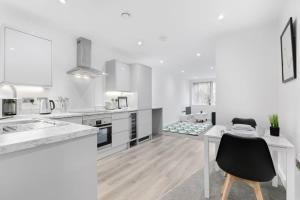 a white kitchen with a desk and a table at Spacious 1 Bedroom Apartment in Central Newbury in Newbury