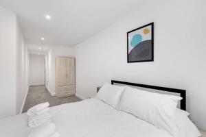 um quarto com uma cama branca e uma cabeceira preta em Spacious 1 Bedroom Apartment in Central Newbury em Newbury