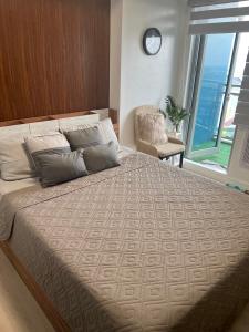 um quarto com uma cama grande e uma janela grande em The Aces Crib at Azure North Pampanga em San Fernando