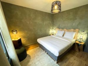 a bedroom with a white bed and a green wall at Logement N2 tout confort - proche de Giverny in Limetz