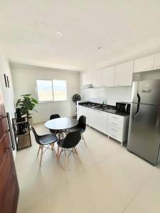 a kitchen with a table and chairs and a refrigerator at Flat Canoa Quebrada in Aracati