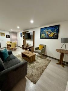 Magnifico y confortable apartamento amoblado # 303 في بوغوتا: غرفة معيشة مع أريكة وطاولة