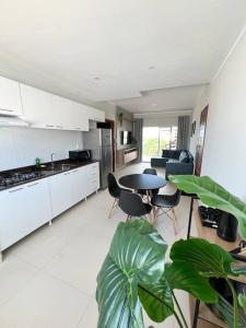 a kitchen with a table and some chairs and a table at Flat Canoa Quebrada in Aracati