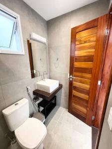 a bathroom with a toilet and a sink at Flat Canoa Quebrada com terraço in Aracati