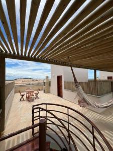 a patio with a hammock and a table and chairs at Flat Canoa Quebrada com terraço in Aracati
