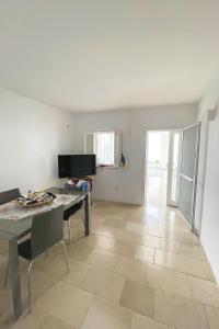 uma sala de estar com mesa e um quarto com piso em Residenza Sole villa al mare con spiaggia privata em Trani