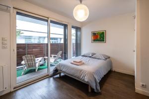 1 dormitorio con 1 cama y balcón en Villa Le Saint-Charles, en París