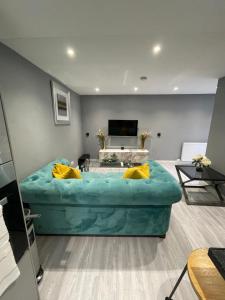 een woonkamer met een grote turquoise bank bij Brook House Annex in Ipswich