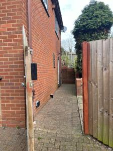 an alley with a brick building and a wooden gate at Brook House Annex in Ipswich