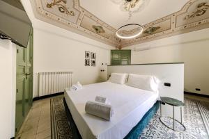 a bedroom with a white bed and a ceiling at Palazzo Villelmi in Cefalù