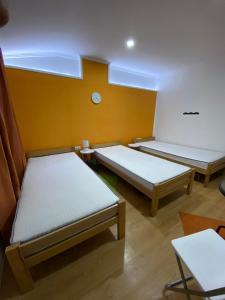 a room with three beds and a clock on the wall at KONTESSA room in Mali Beograd