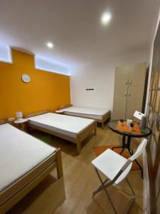 a room with two beds and a table and chairs at KONTESSA room in Mali Beograd