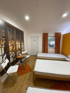 1 dormitorio con 2 camas, mesa y sillas en KONTESSA room, en Mali Beograd