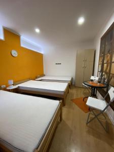 a room with three beds and a table and a chair at KONTESSA room in Mali Beograd