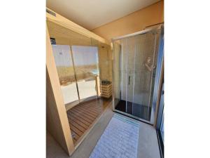 a walk in shower with a glass door in a room at Glycine Jasmim in Castro Marim