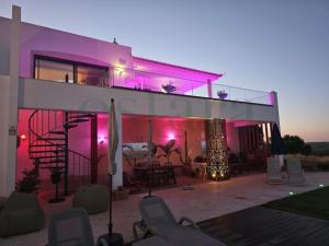 una casa con luces rosas en el costado. en Glycine Jasmim, en Castro Marim