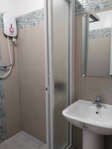 Kathy's Place at Cold Spring في Catarman: حمام مع حوض ودش مع مرآة
