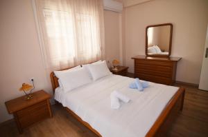 a bedroom with a large white bed with a mirror at Nana's & Pepi's House in Kastoria