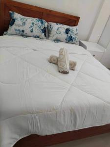 Kathy's Place at Cold Spring في Catarman: سرير ابيض وفوط ملفوفة عليه