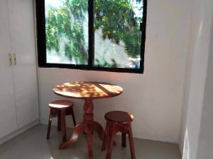 a table and two stools in a room with a window at Kathy's Place at Sto Niño Cold Spring in Catarman