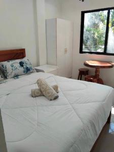 a bedroom with a white bed with two pillows on it at Kathy's Place at Cold Spring in Catarman