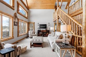 a living room filled with furniture and wooden ceilings at Maple Lake Chalet in Buffalo