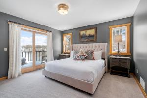 a bedroom with a white bed and a balcony at Maple Lake Chalet in Buffalo