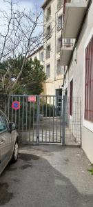 un portail avec une voiture garée devant un bâtiment dans l'établissement Mer&Soleil, à Sète