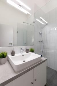 une salle de bain blanche avec un lavabo et un miroir dans l'établissement Central City Apt in the Jewish Quarter with FREE PARKING, à Budapest