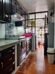 a kitchen with a sink and a stove at Apartamento 32 Juana de Arco in Quito