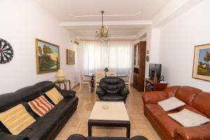 ein Wohnzimmer mit Ledersofas und ein Esszimmer in der Unterkunft Vintage Blloku Apartment in Tirana