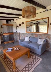 a living room with a couch and a coffee table at Establecimiento La Soleada suites de campo in La Cumbre