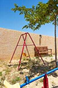 a swing and a bench in front of a wall at CASA RURAL EL PINICO in Yeste