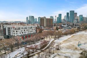 a city skyline with tall buildings and trees in the snow at Bridgeland Loft, Downtown, Modern, Pet Friendly in Calgary