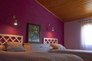 1 dormitorio con 2 camas y pared púrpura en CASA RURAL EL PINICO en Yeste