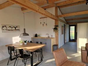 a kitchen and dining room with a table and chairs at De Wilde Tuin in Moergestel