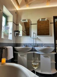 a bathroom with two sinks and a glass of wine at Villa Monica in Ložišće