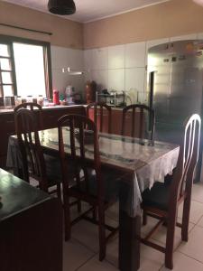 cocina con mesa, sillas y nevera en Chácara Vale Verde, en São Lourenço da Mata