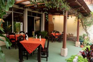 een restaurant met rode tafels en stoelen op een patio bij Hostal Donde Regina in Guatemala