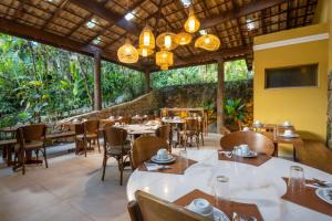 a restaurant with tables and chairs and a large window at Pousada Naturalia in Abraão