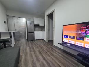 a living room with a flat screen tv and a kitchen at Apartment Udine in Udine