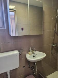 a bathroom with a sink and a toilet and a mirror at Sanda in Novi Vinodolski +3 photos